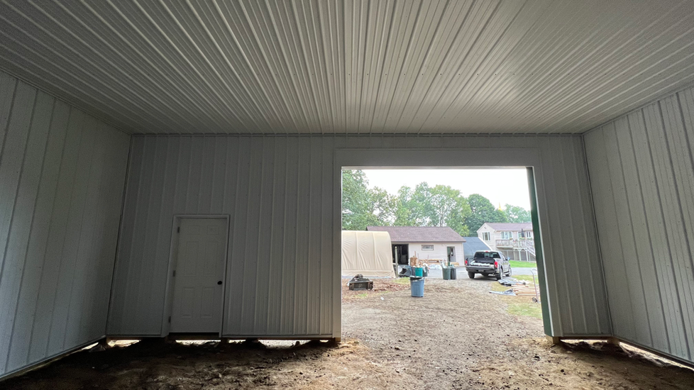 The inside of a white garage with a door open.