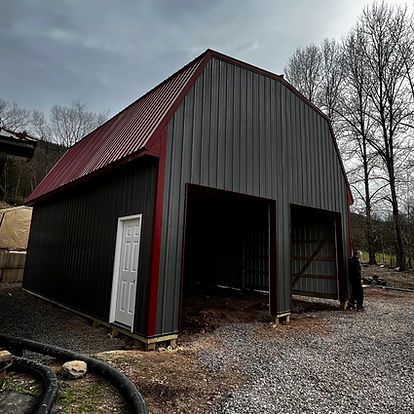 A large barn with a red roof is being built.