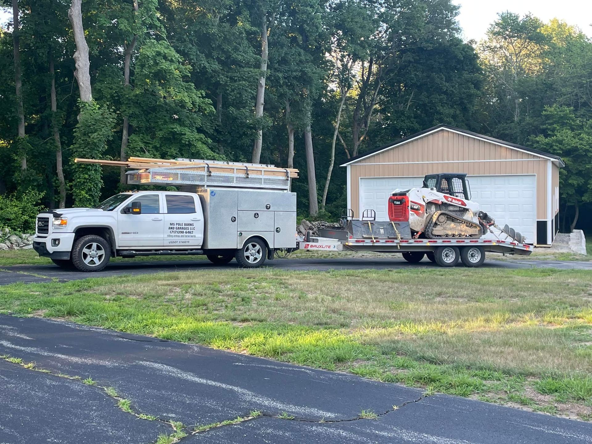 A white truck is towing a bulldozer on a trailer.