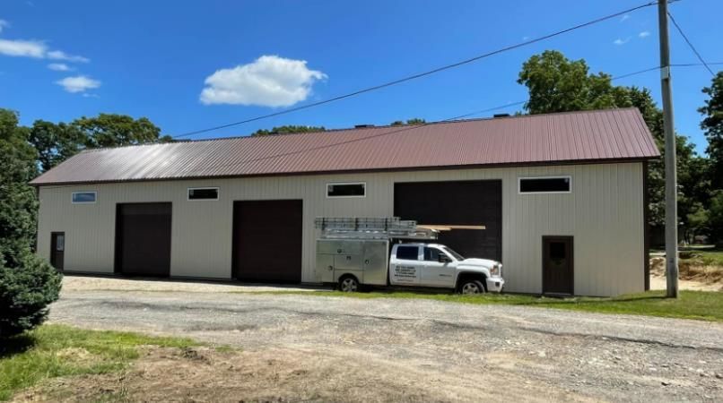 A white truck is parked in front of a large building.