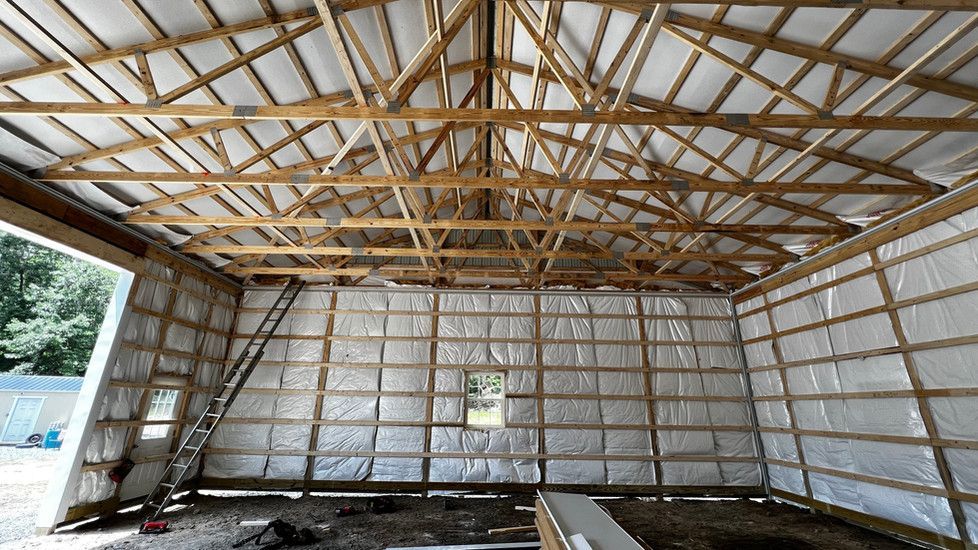The inside of a building under construction with wooden beams and insulation.