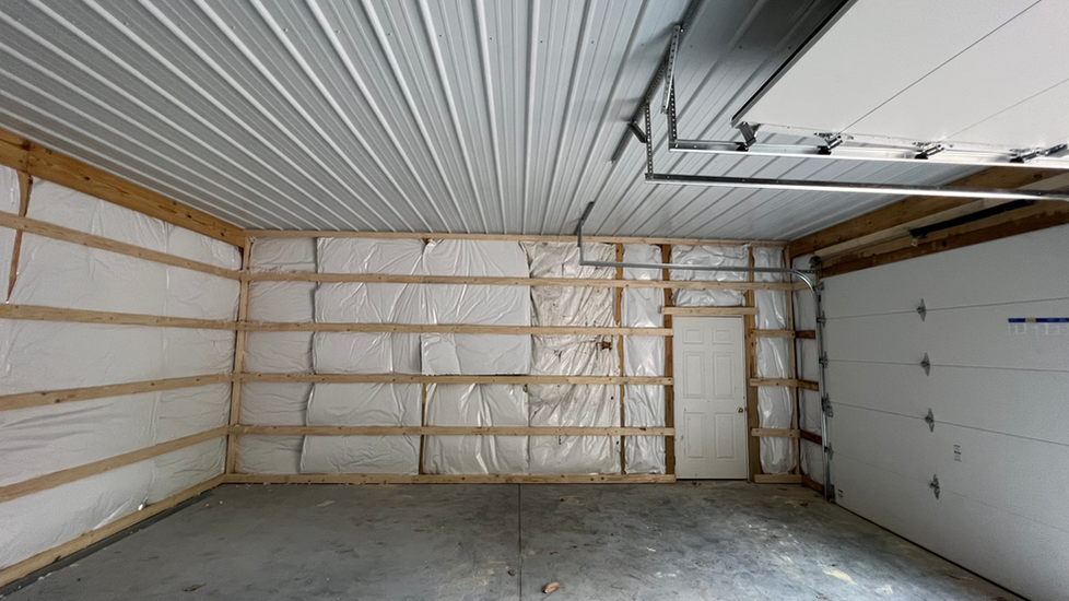 An empty garage with insulation on the walls and ceiling.