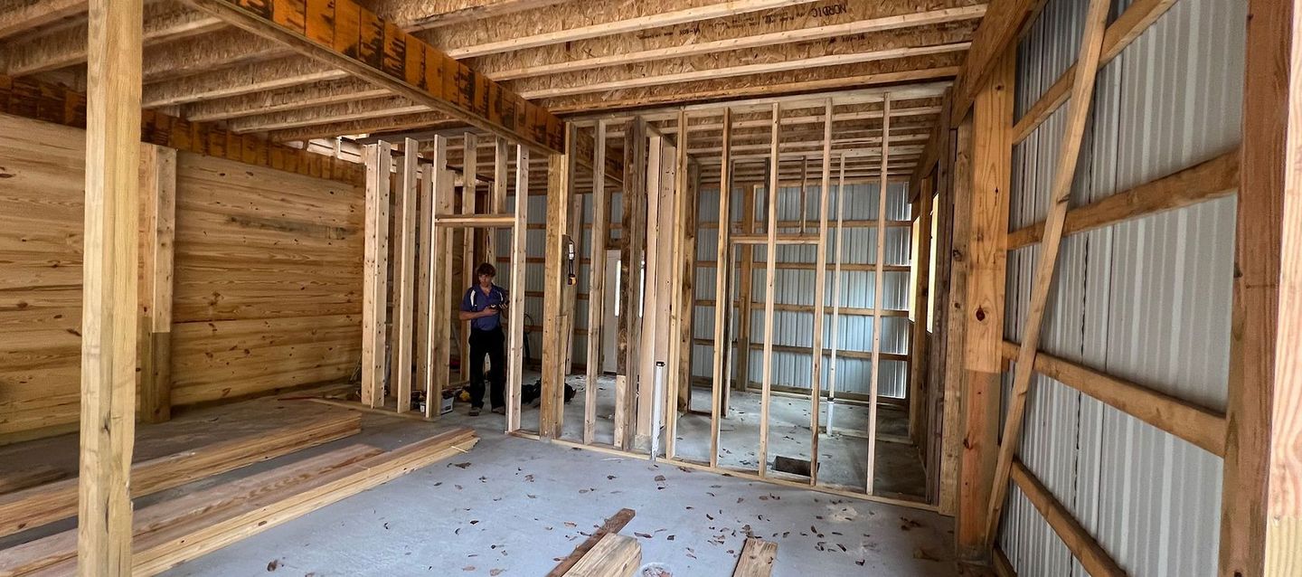 A man is standing inside of a building under construction.