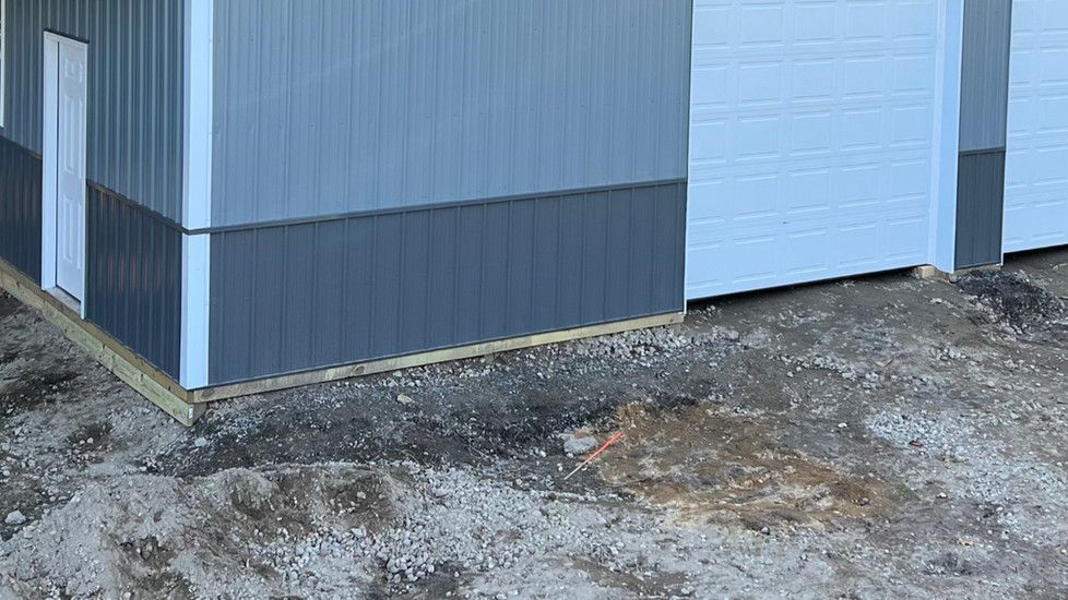 A corner of a building with a garage door and a doorway.