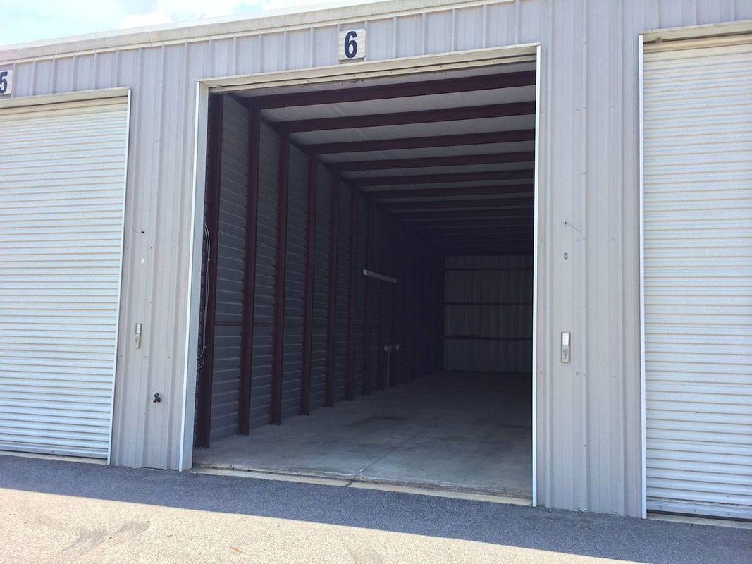 An empty garage with the doors open and the number 6 on the side.