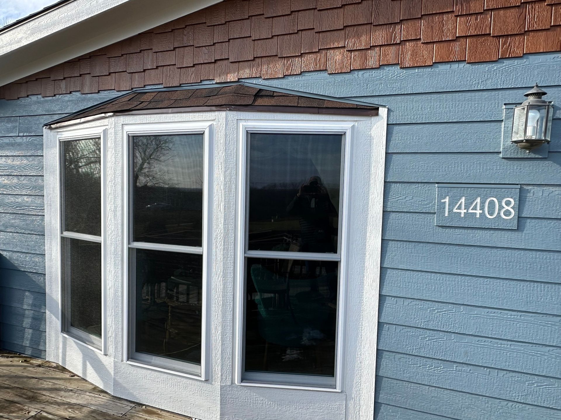 Blue house exterior with bay window, brown shingle siding, and address 14408.