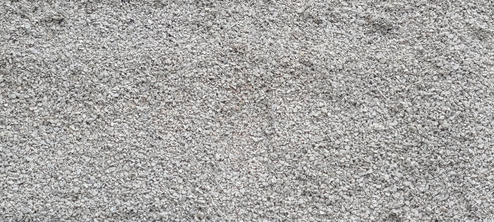 Gray gravel or coarse concrete surface filling the frame