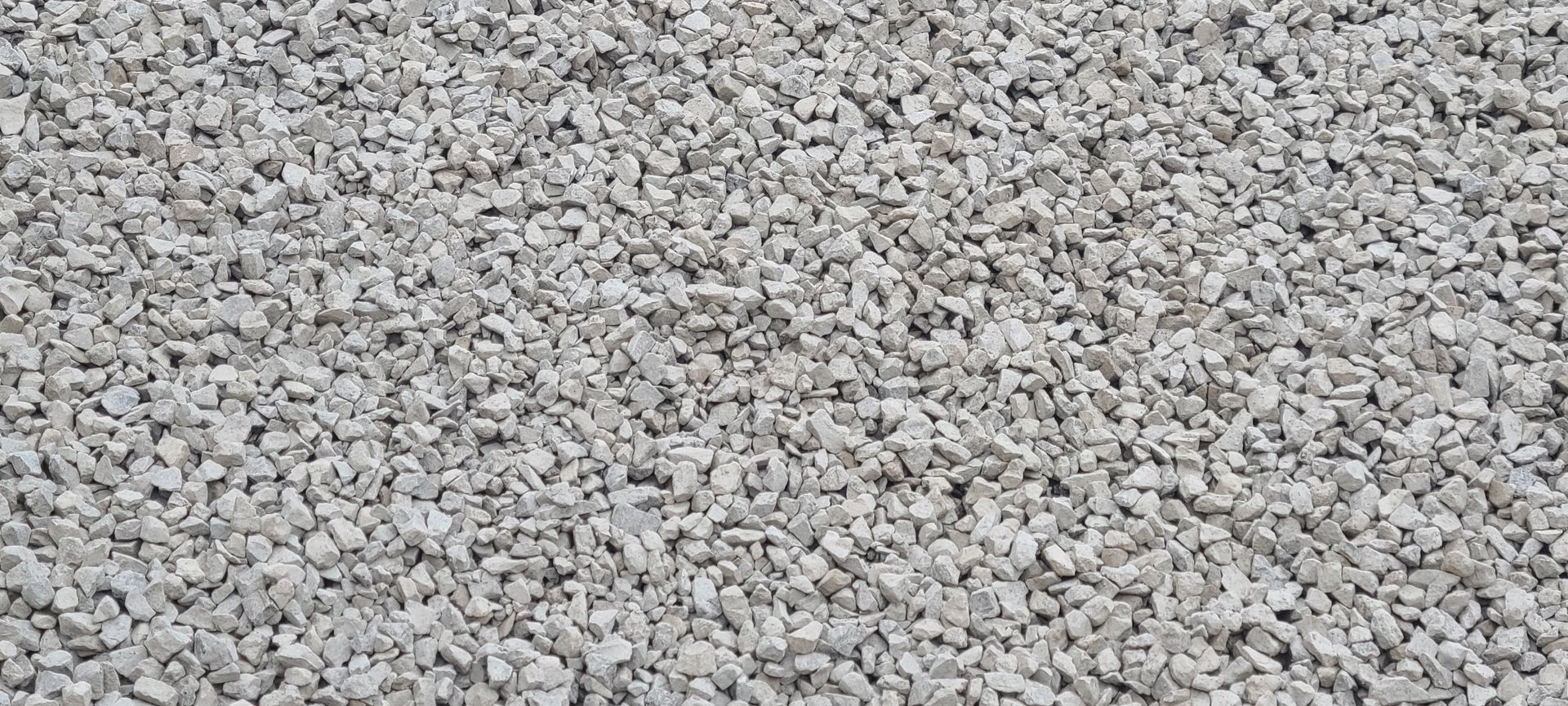Close-up of a light gray gravel surface with small stones densely packed together