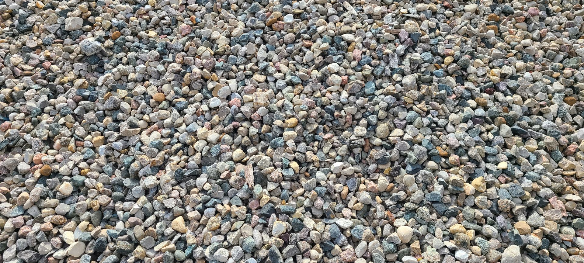 Pebbled ground covered with small gray, tan, and blue stones
