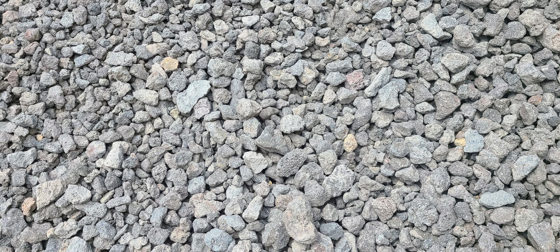 Close-up of a gray gravel or crushed stone surface with small rocks filling the frame