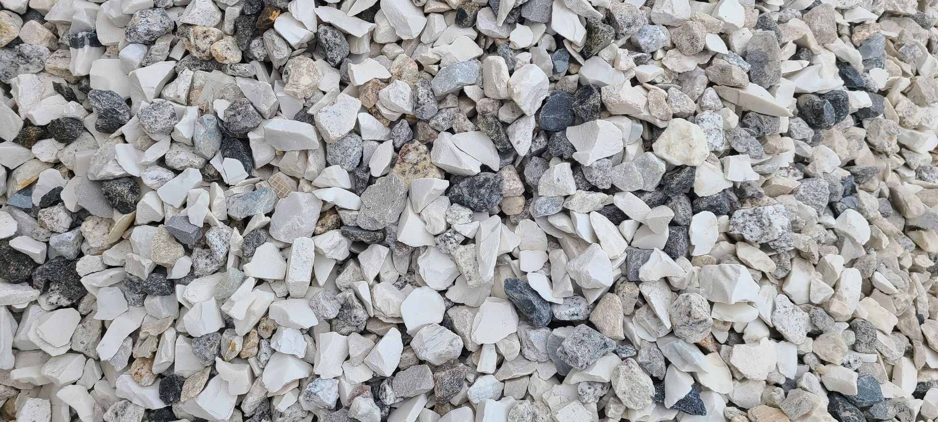 Close-up of light gray and white gravel stones filling the frame