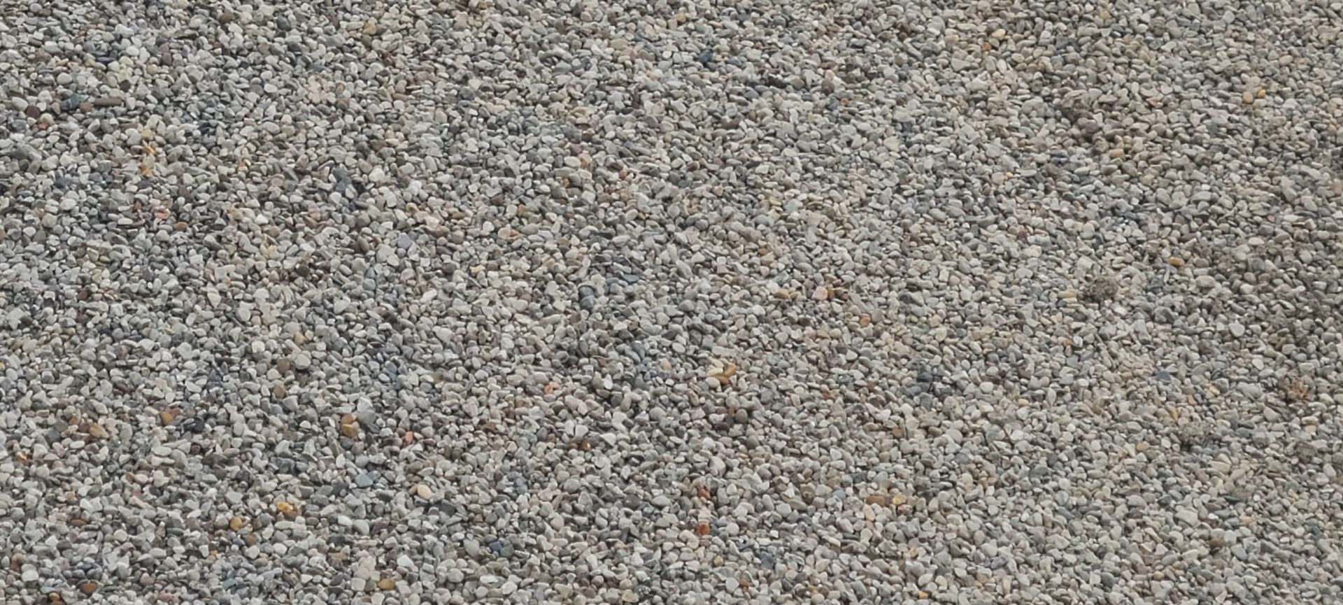 Close-up of a gray and beige speckled gravel or pebble surface
