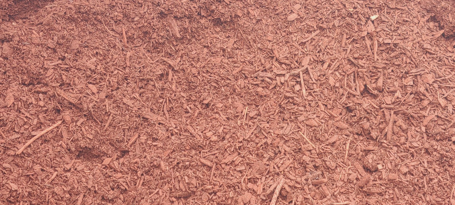 Pinkish-brown mulch covering the ground in a close-up texture