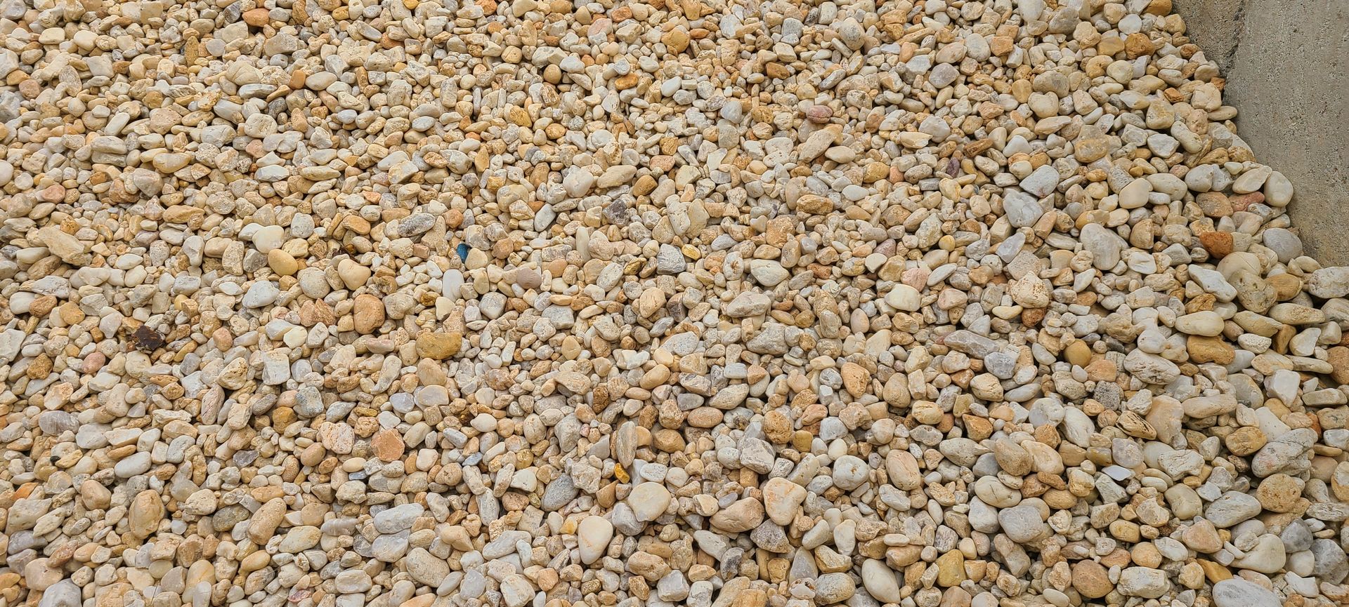 Close-up of small beige and gray pebbles covering the ground