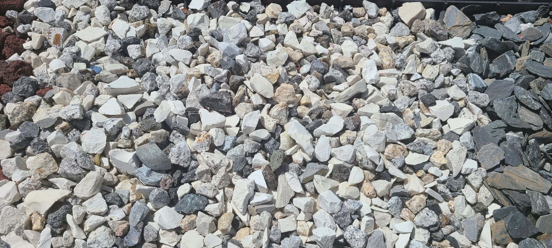 Pile of mixed gray and white gravel stones filling the frame
