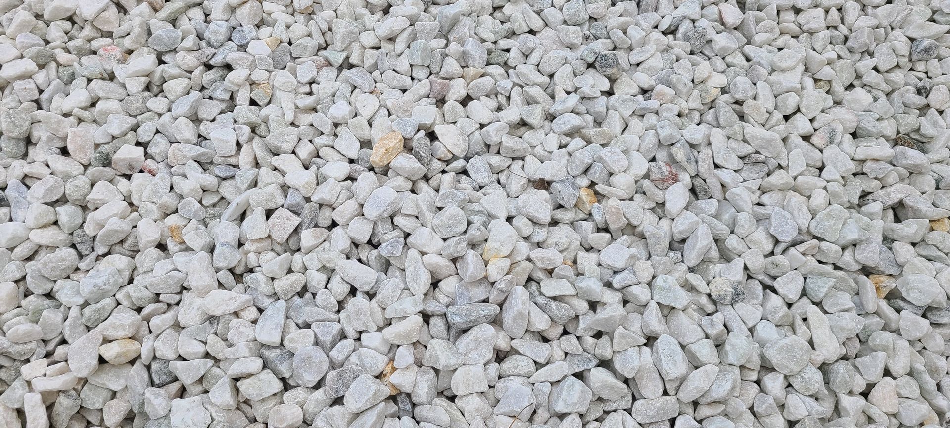 Close-up of light gray gravel stones with a few tan pebbles scattered throughout