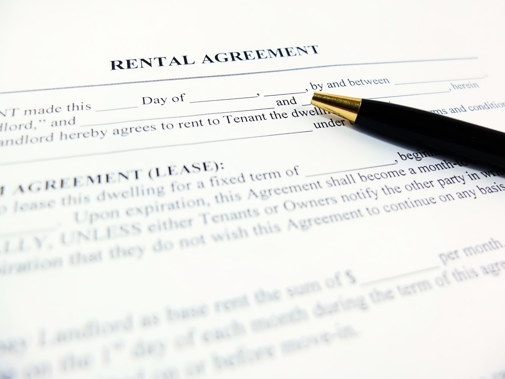 Rental agreement document with a pen resting on it.