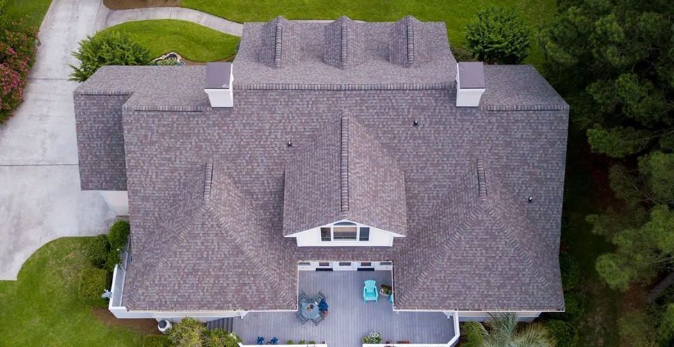 An aerial view of a large house with a gray roof