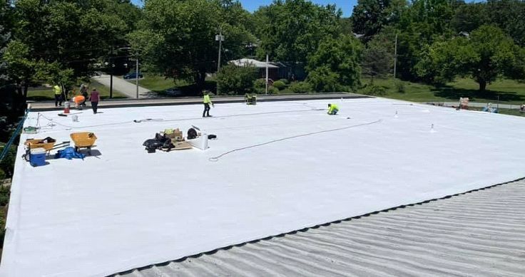 A group of people are working on a white roof