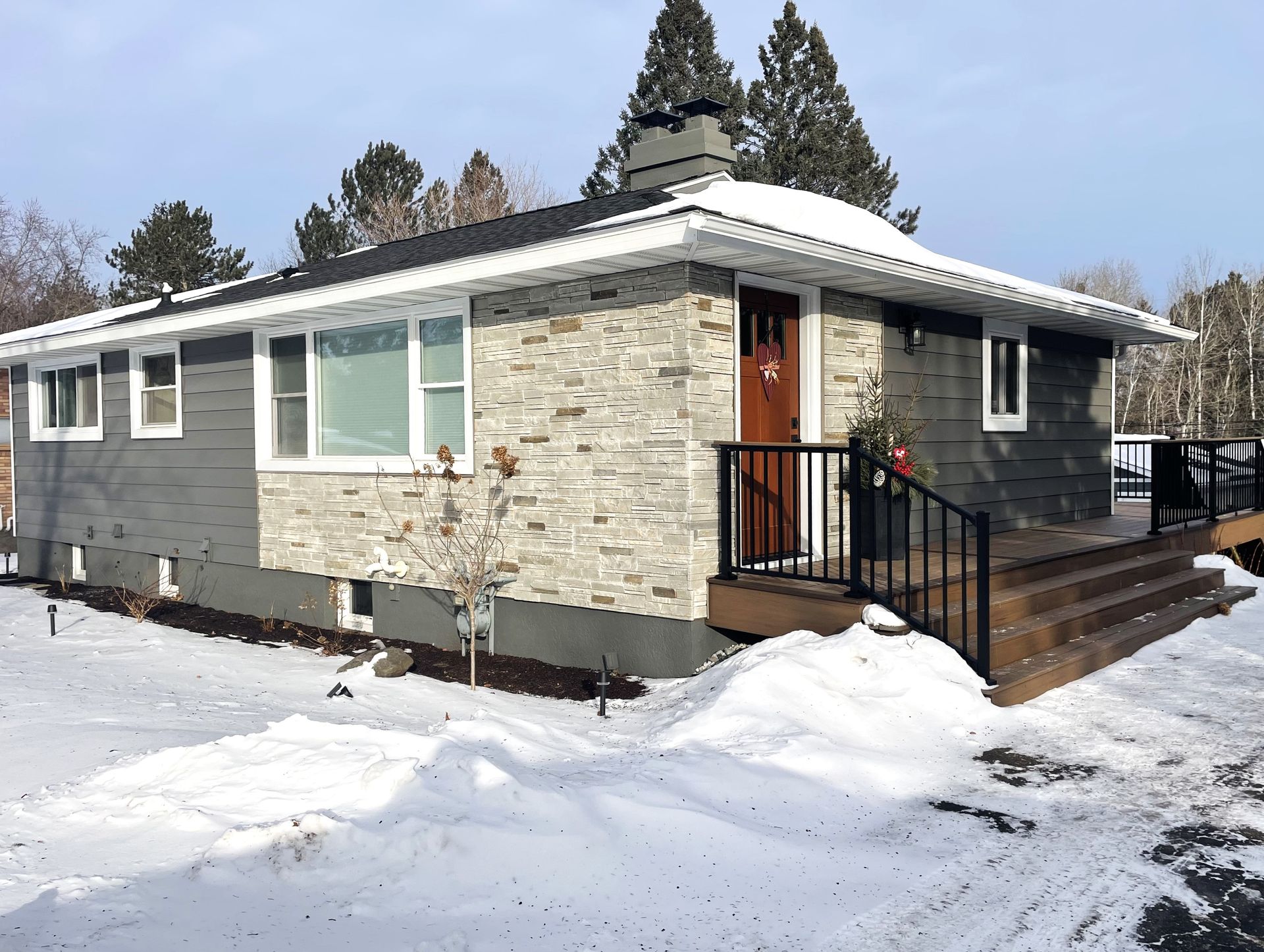 A house with snow on the ground in front of it