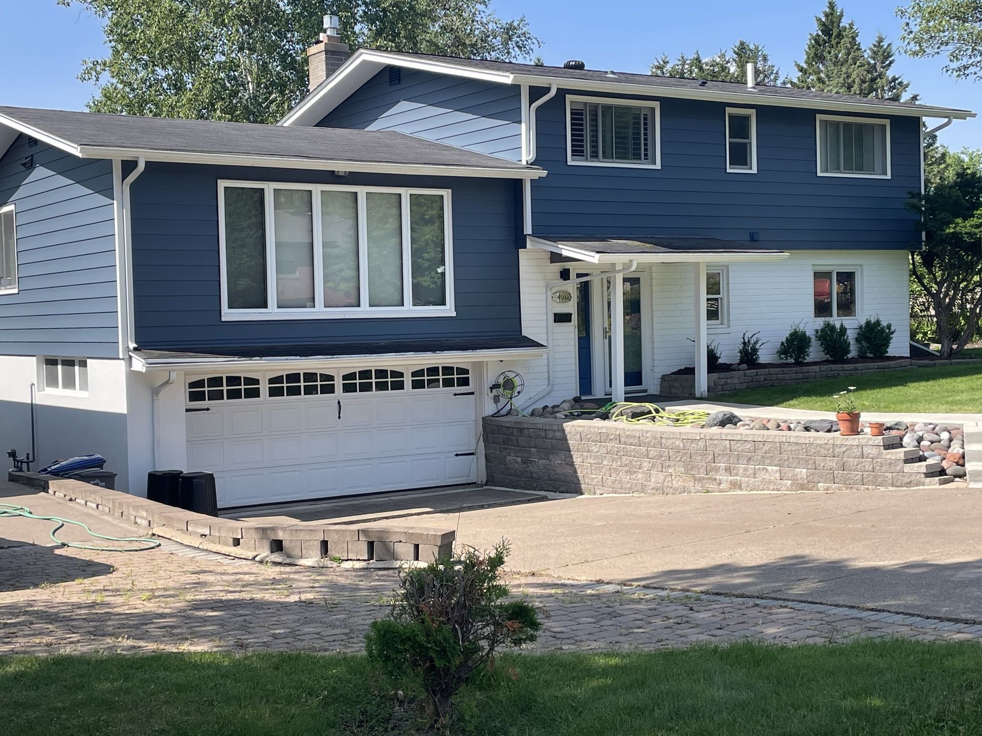 A large house with a blue siding and a white garage door.
