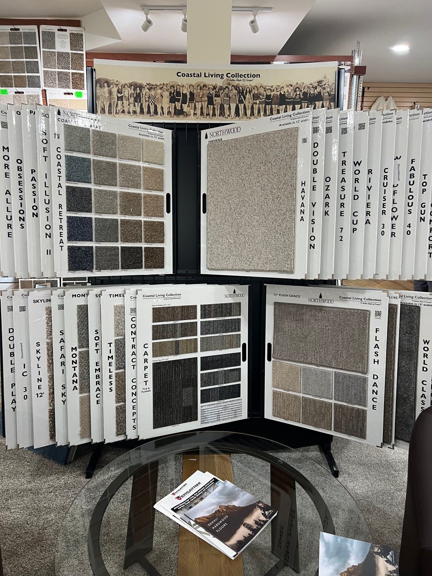 Display of laminated samples and white folding panels arranged on a black stand at an indoor exhibit