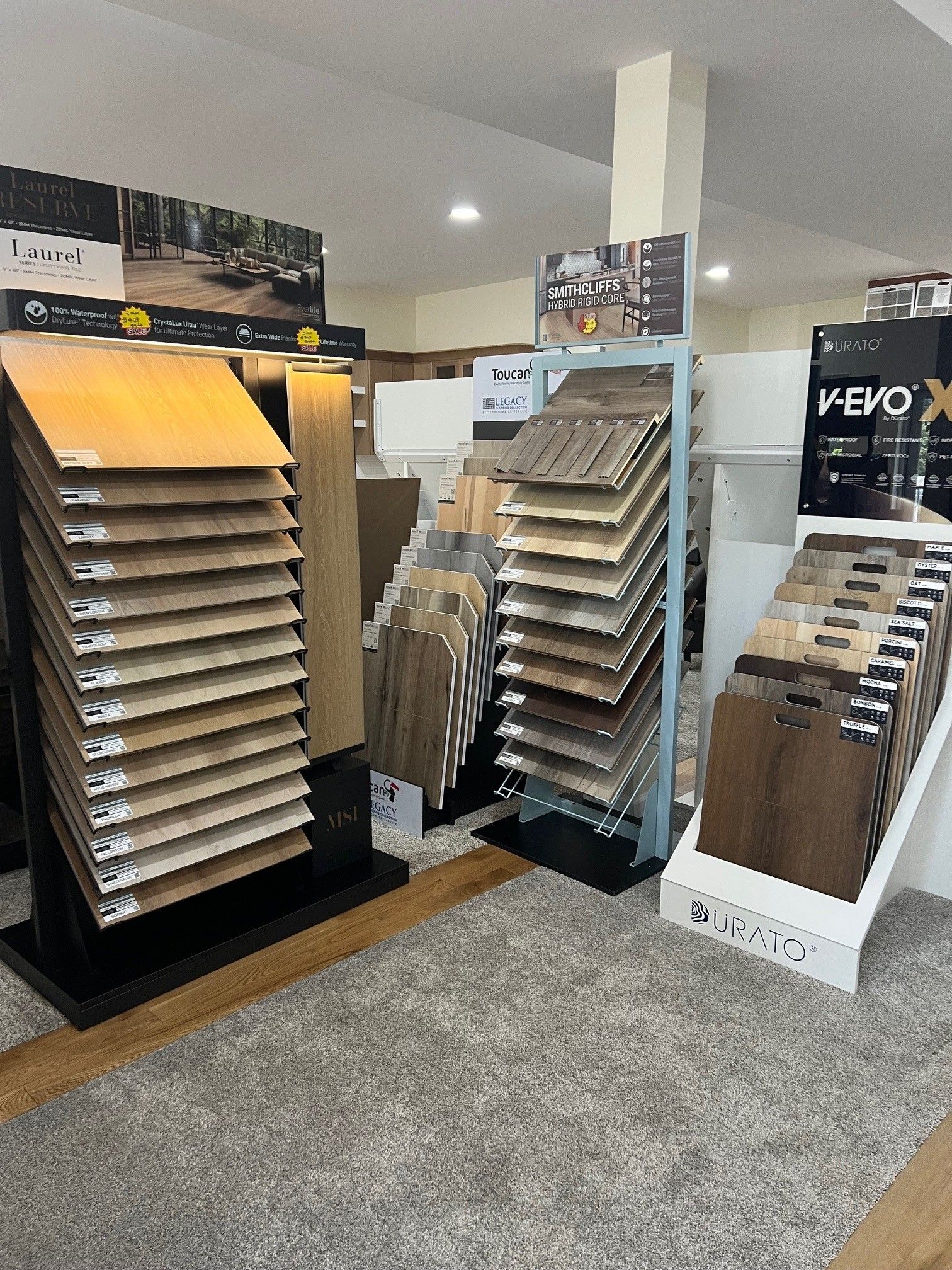 Display of flooring samples in a showroom with carpeted floor and wall-mounted sample racks