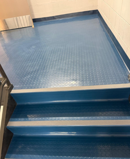 Blue-painted stair landing and steps in a tiled interior hallway.