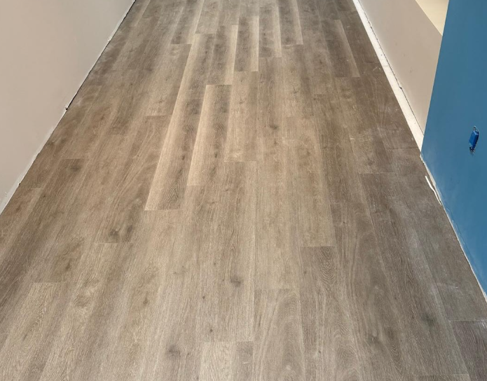 Empty hallway with light wood flooring and blue wall on the right