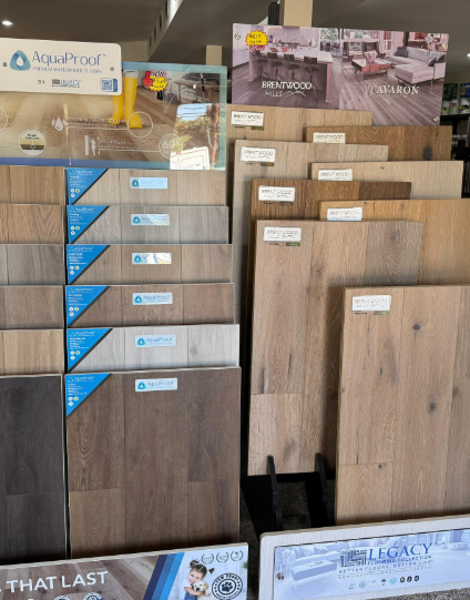 Wood flooring and laminate samples displayed on showroom racks with wood-grain swatches and labels
