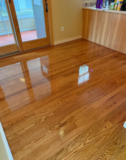 Shiny hardwood floor in a room with sliding glass doors and a wood cabinet counter
