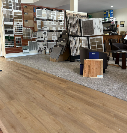 Flooring showroom with wood samples, tile displays, and carpeted display area
