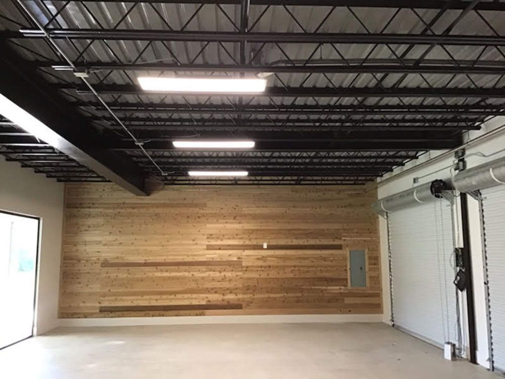 A large empty room with a wooden wall and a metal ceiling