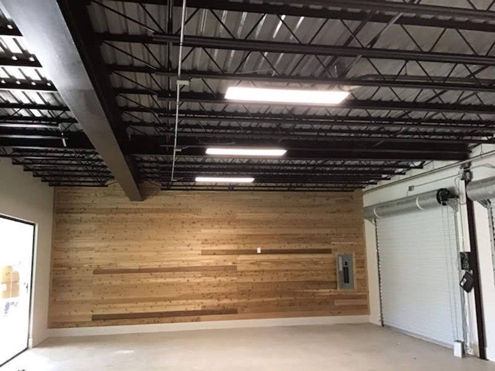 A well-lighted large empty room with a wooden wall