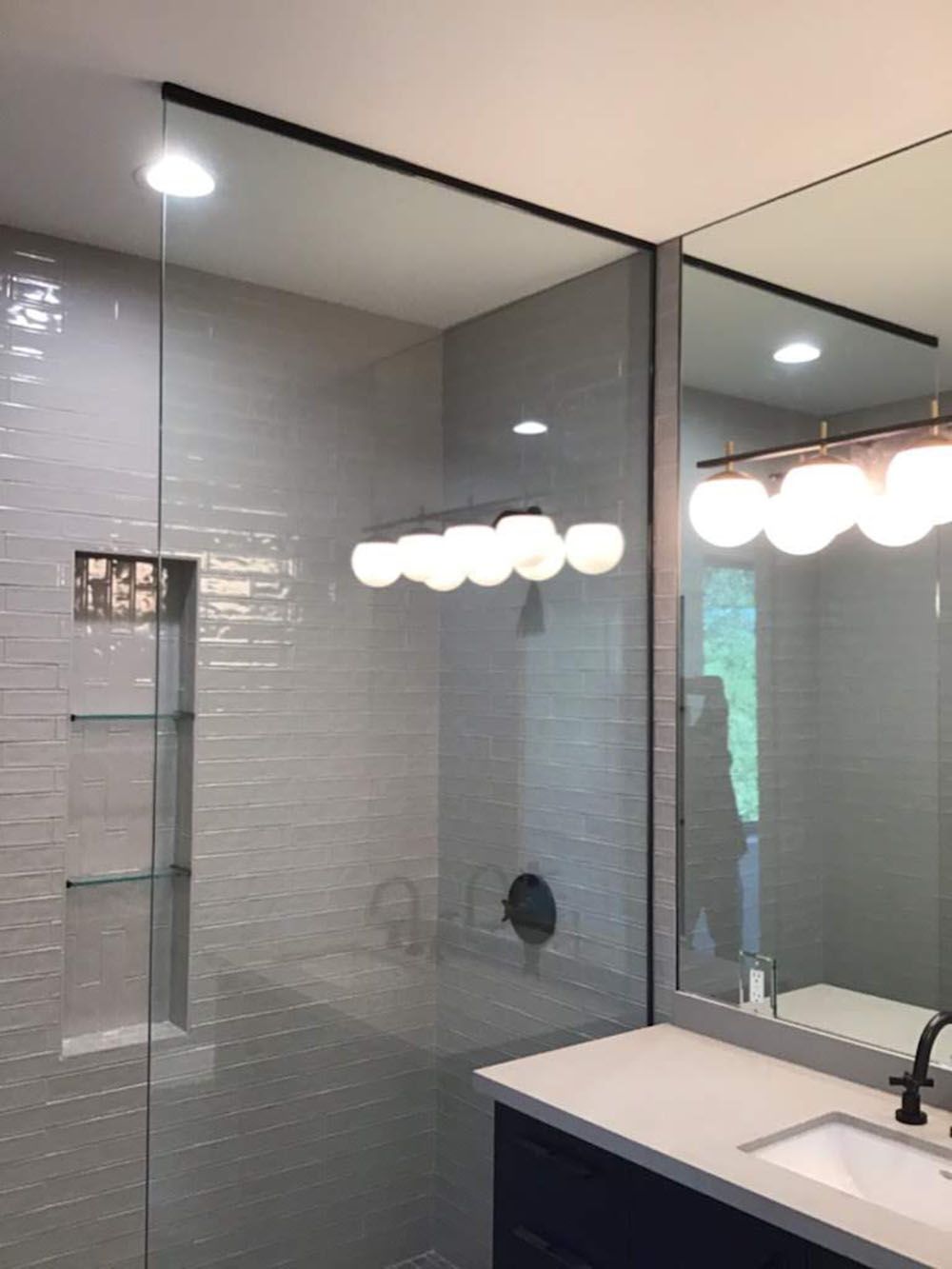 A well-lighted bathroom with a sink and a large mirror