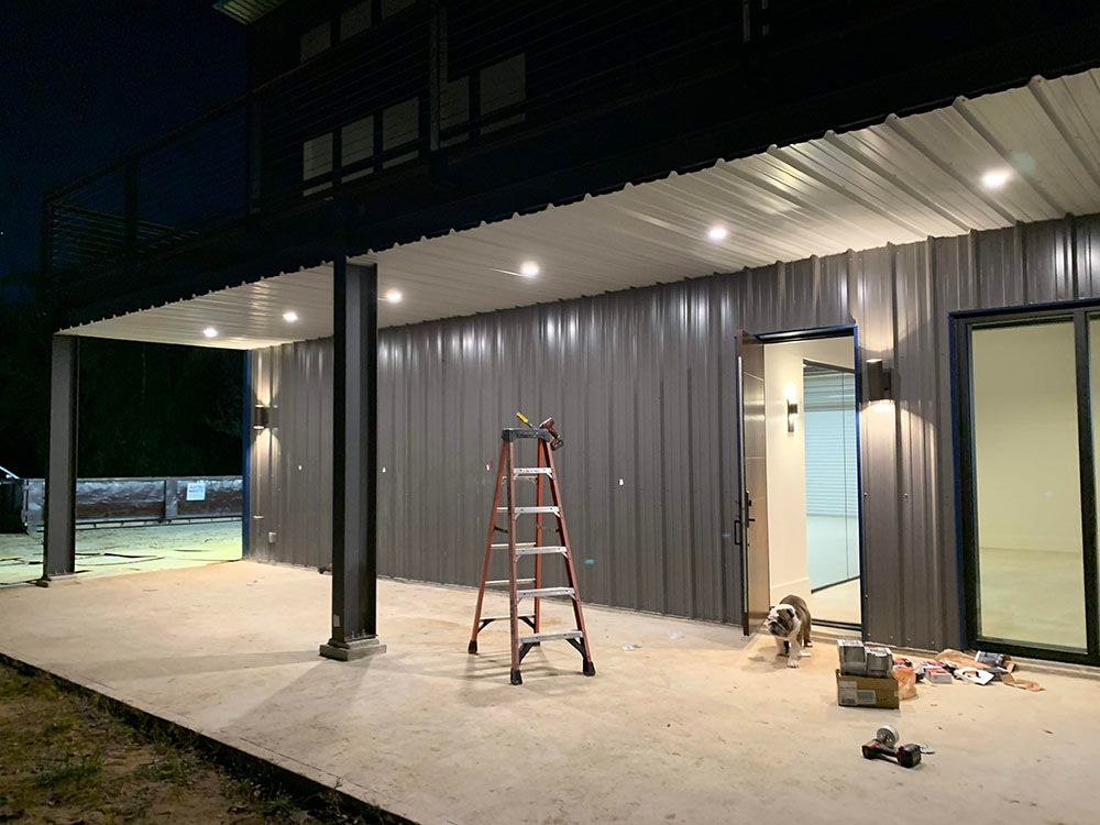 A ladder is sitting on the side of a well-lighted building