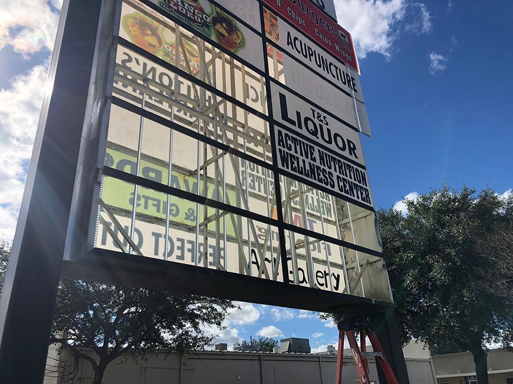 A large billboard with a lot of signs on it