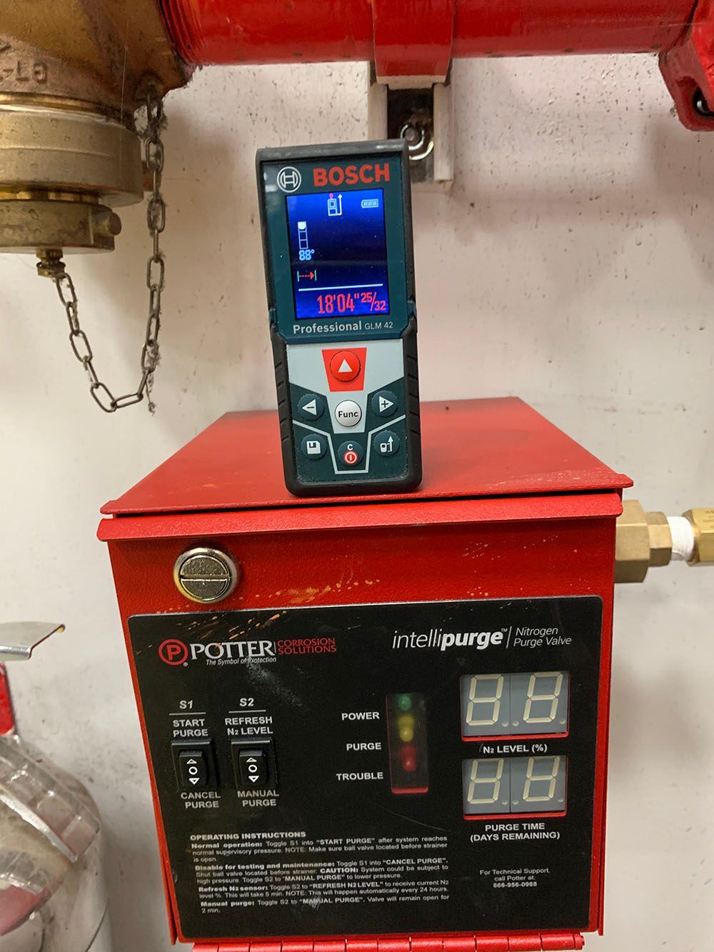 A bosch device is sitting on top of a red box