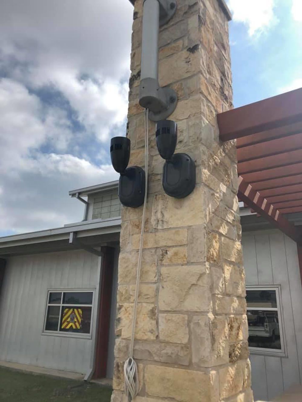 A brick post with lights attached to it