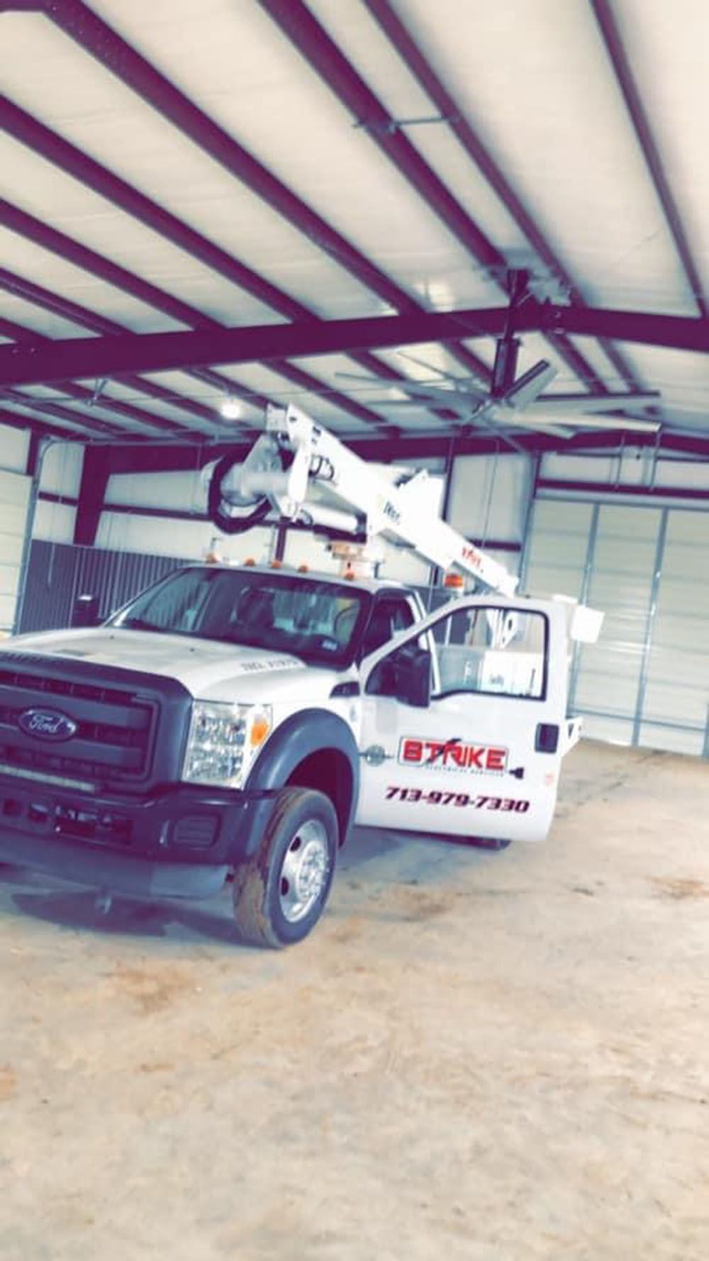 A white truck with a crane on top of it