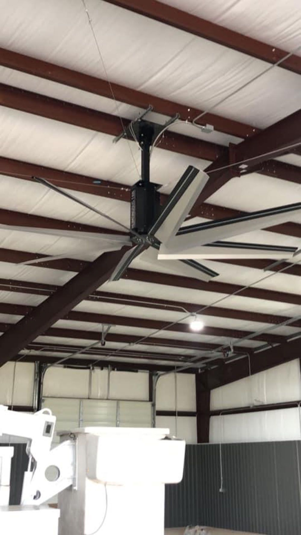 A large ceiling fan is hanging from the ceiling of a building