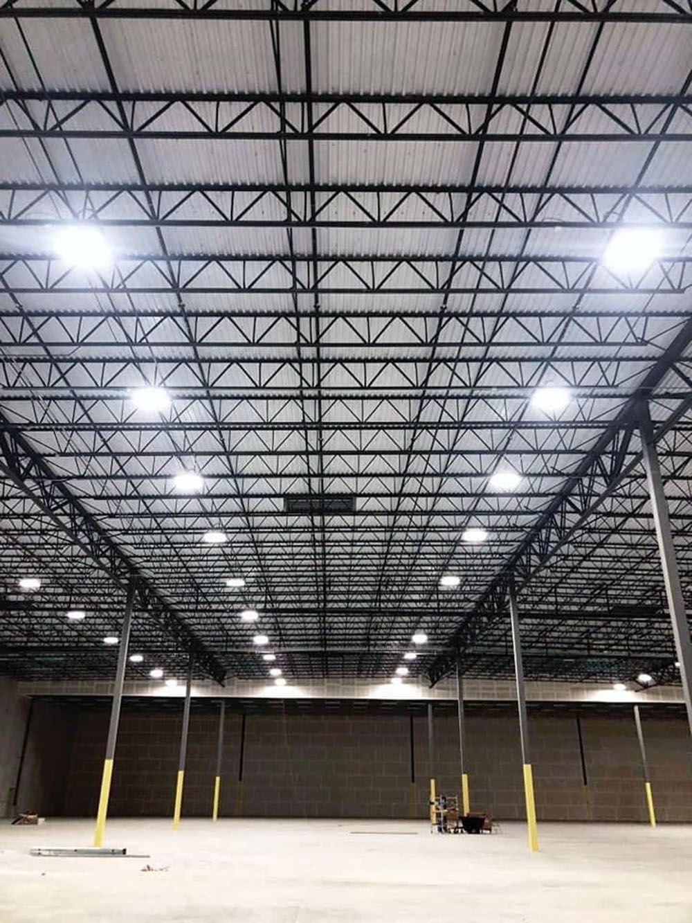 The inside of a large warehouse with lots of lights on the ceiling