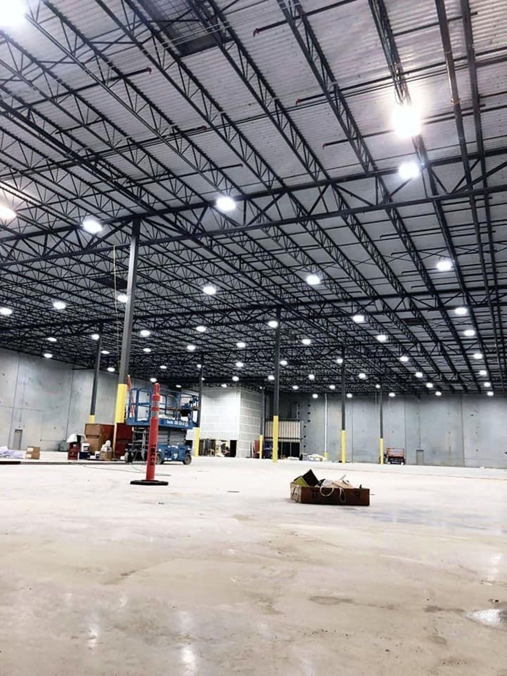 A large warehouse with a lot of lights on the ceiling