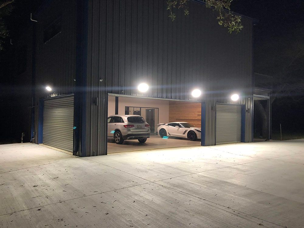 Two cars are parked in a well-lighted garage