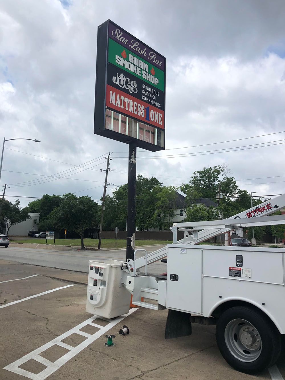 A white truck is parked in front of a large sign