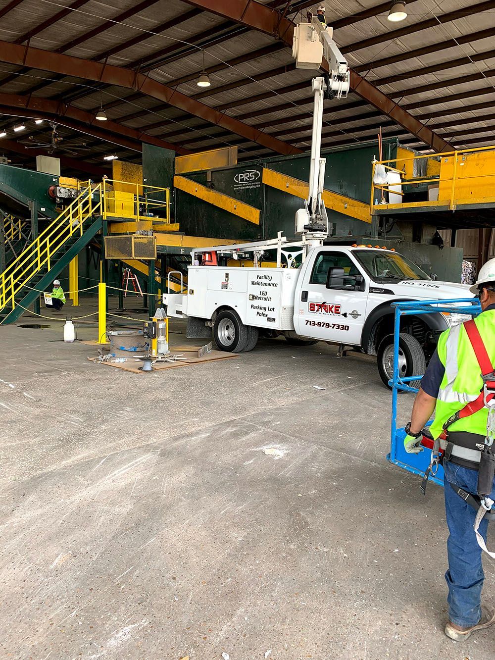 A man is standing in front of a truck in a warehouse