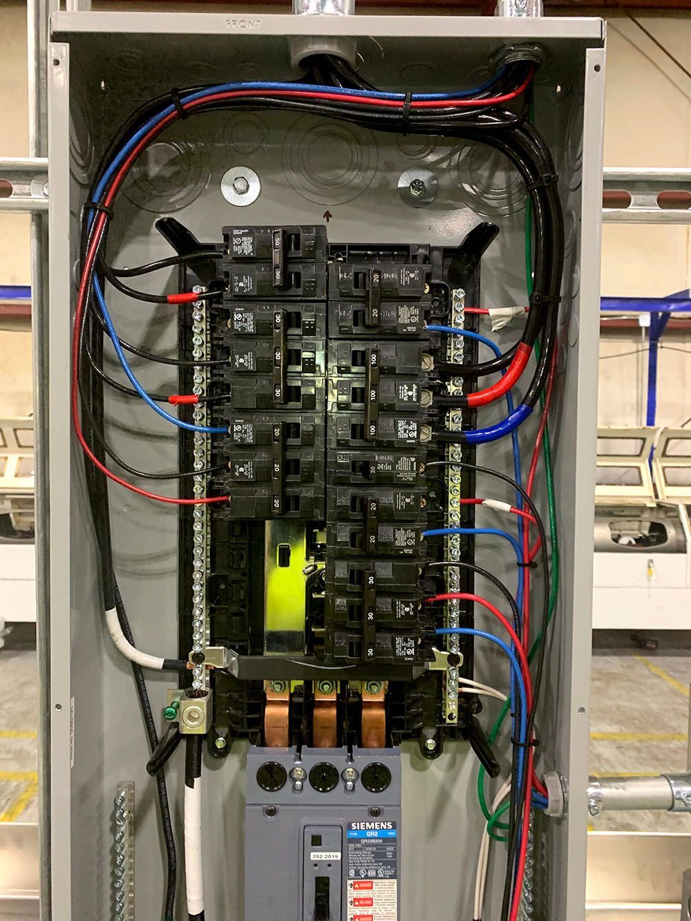 An electrical panel with a lot of wires coming out of it