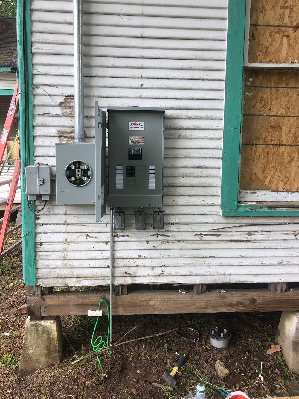 An electrical box is installed on the side of a house
