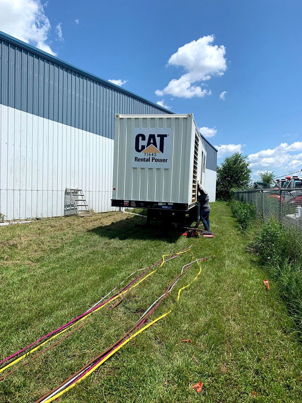 A white generator is sitting next to a building