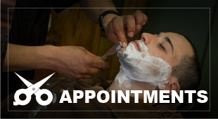 Man getting a shave at a barber shop, lather on face, razor in hand, with